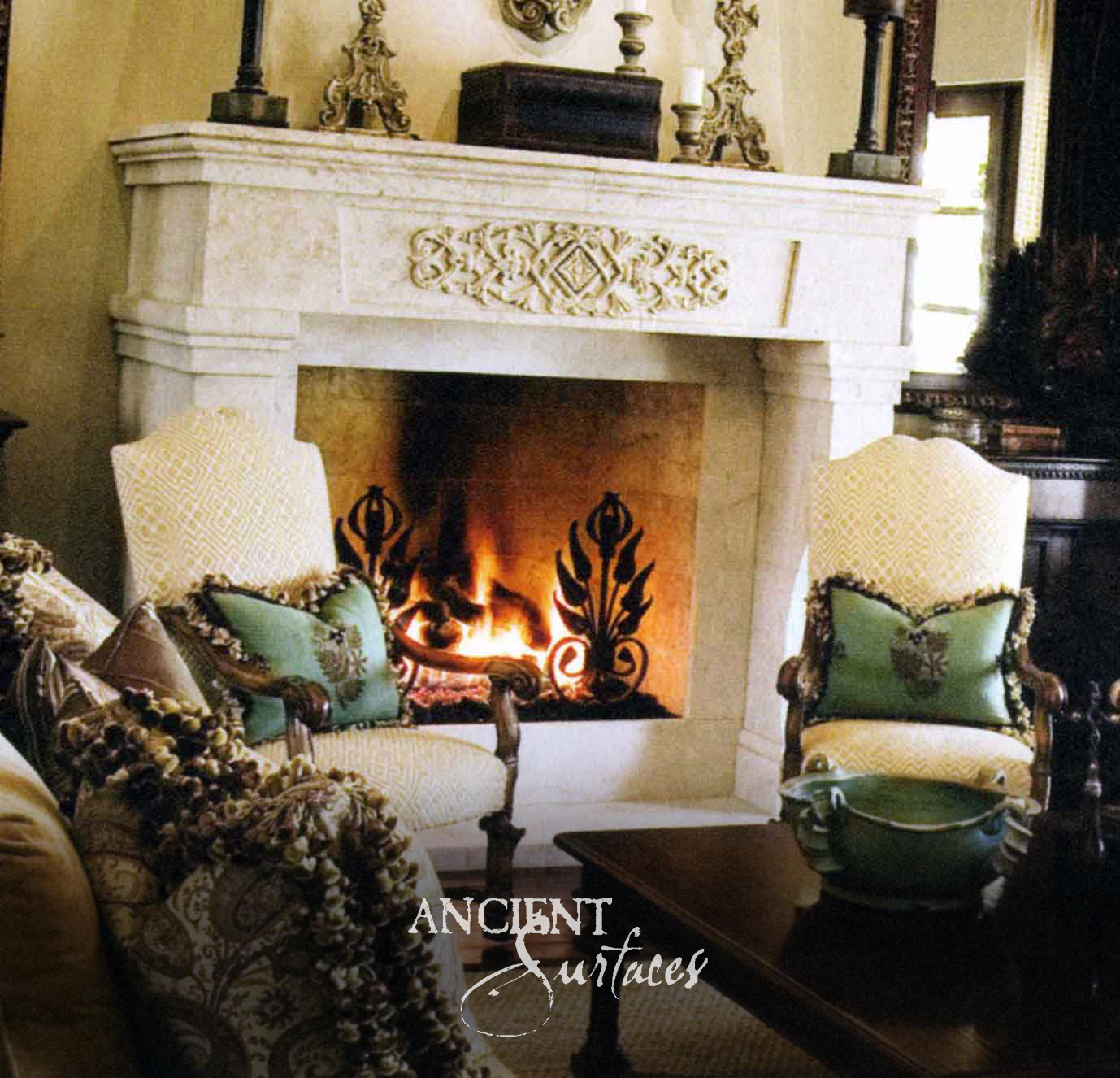 Cream reclaimed limestone fireplace mantel with a single carved foliate tablet at the centre of a plain frieze and flat pilaster jambs