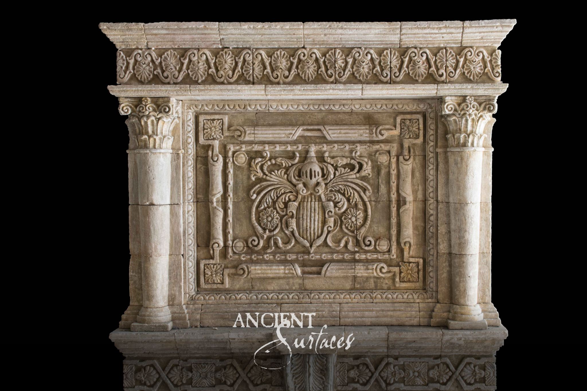 Monumental reclaimed limestone chimneypiece with a carved armorial overmantel panel, palmette cornice band and acanthus capped columns