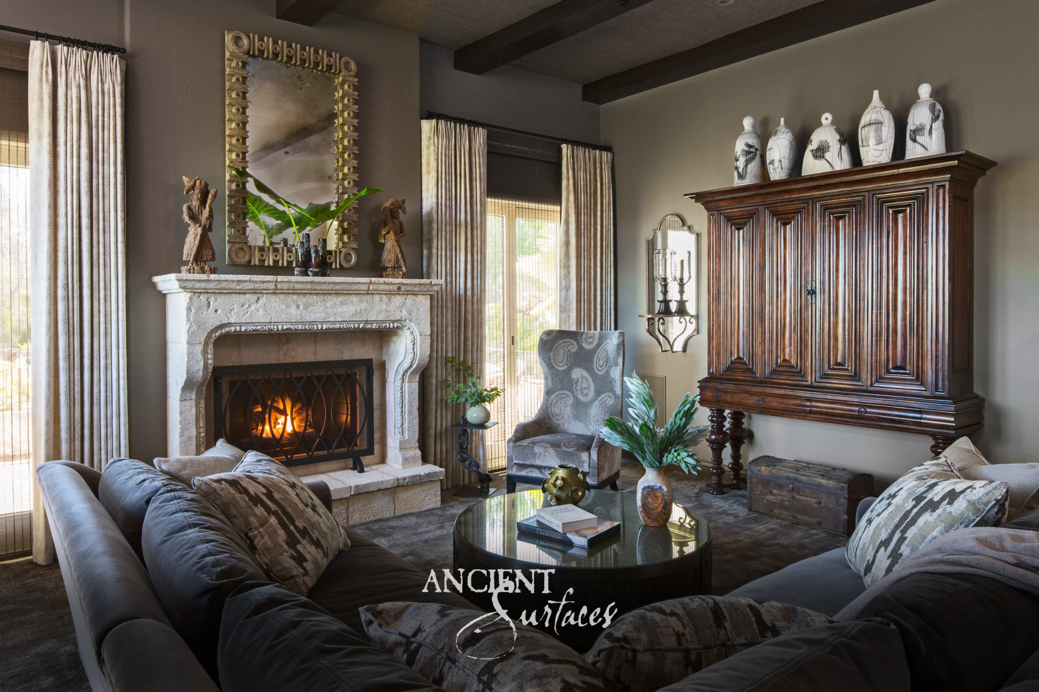 Pale reclaimed limestone fireplace mantel with long scrolled corbels on a plain frieze and a shaped molded opening above a stepped stone hearth