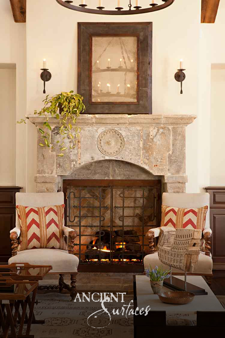 Heavily weathered reclaimed limestone fireplace mantel with a worn rosette medallion on a broad frieze above a shallow segmental arched opening
