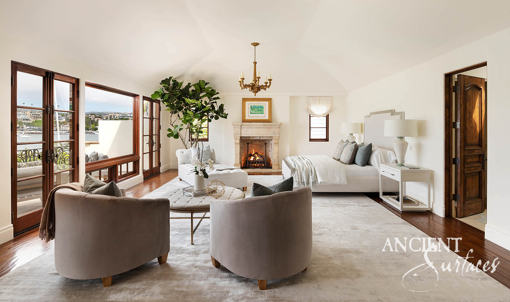 Pale sandy reclaimed limestone fireplace mantel with a molded shelf, corbel ends and a low brick lined arched opening in a bright room