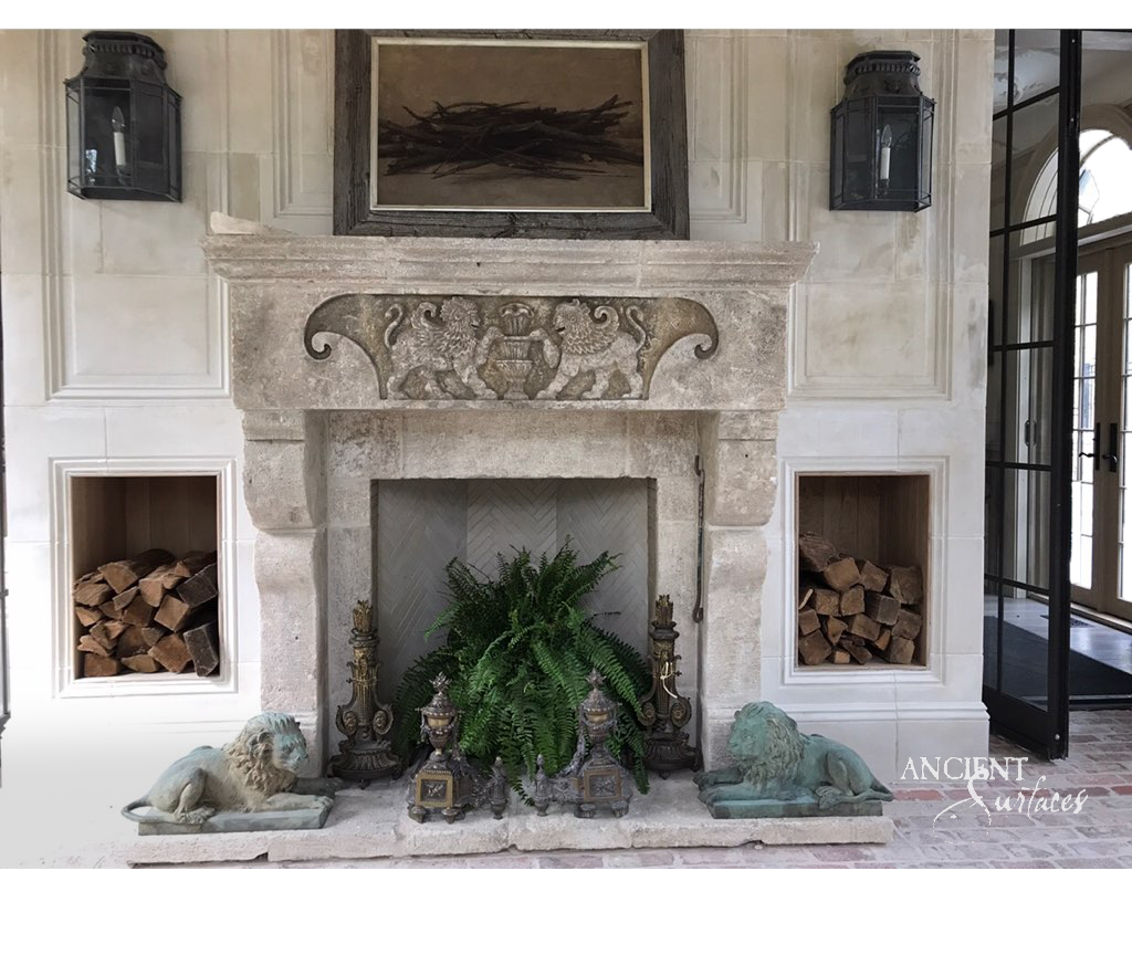 Broad reclaimed limestone chimneypiece with a frieze carved with two facing lions flanking a fluted urn, scrolled end volutes and heavy shaped corbels