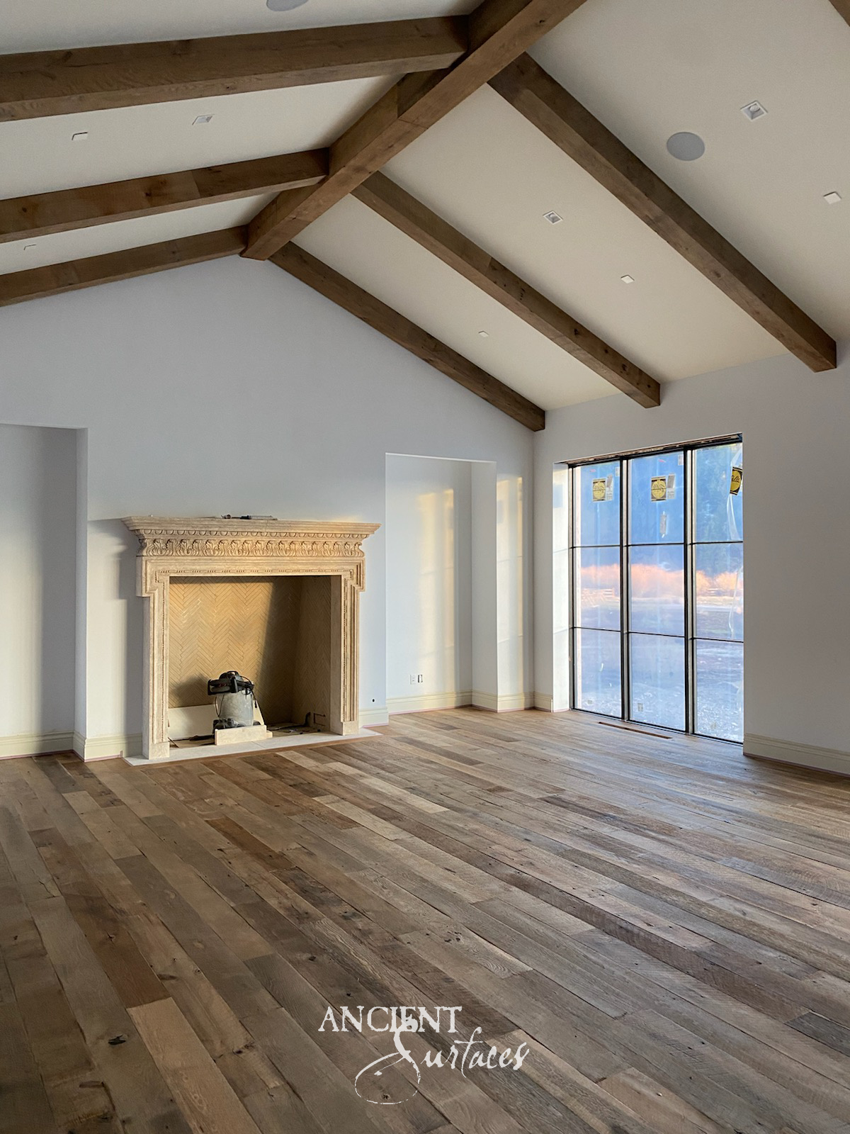 Reclaimed limestone fireplace mantel with a cornice carved in large lobed ornaments above a reeded frieze, breaking forward over scrolled corbel brackets