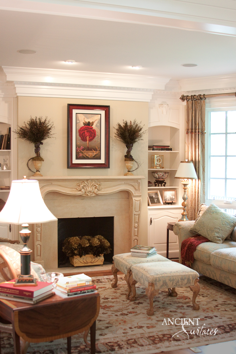 Cream reclaimed limestone fireplace mantel with a serpentine shelf, carved shell and scroll cartouche on the arched frieze and curved jambs with leaf drops